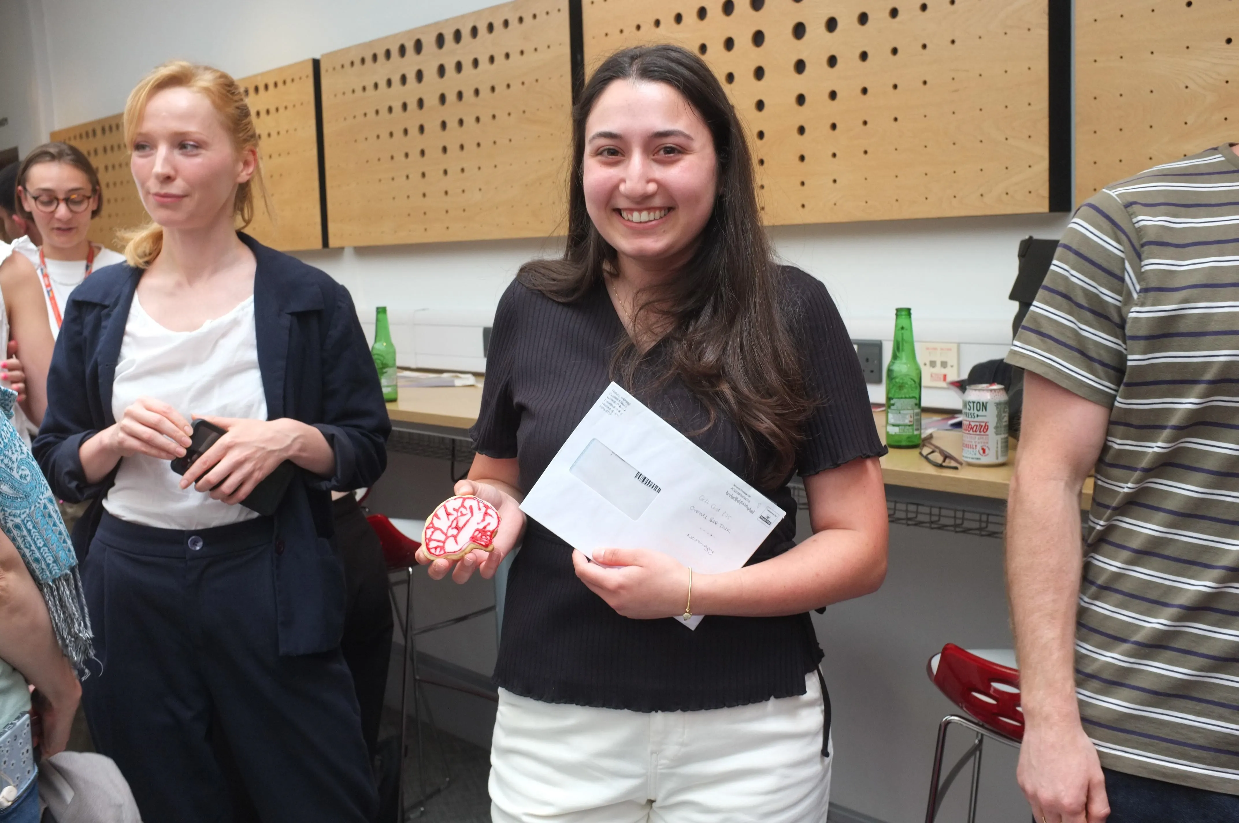 PhD student smiling with their prize for the best presentation