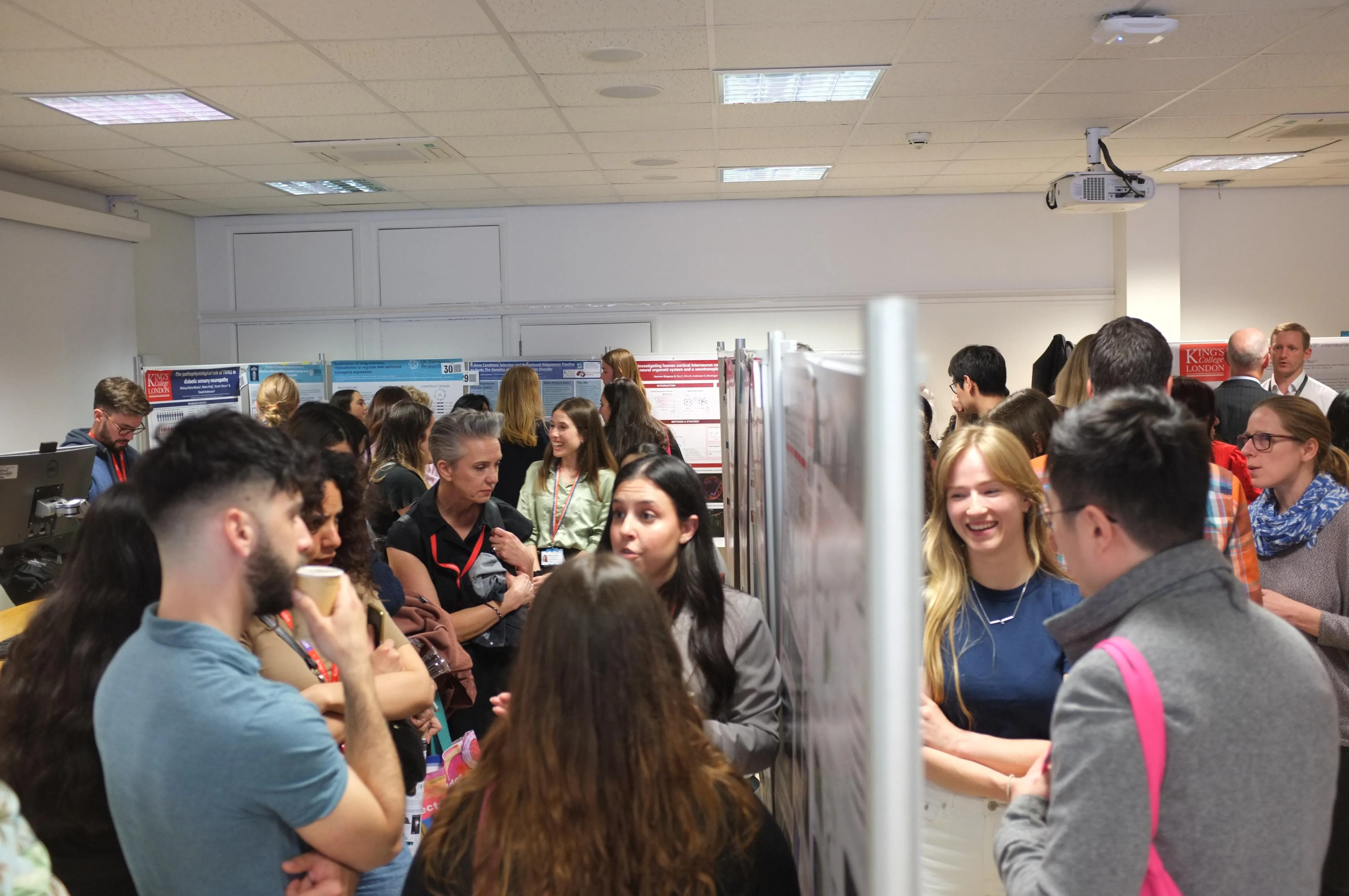 Attendees of the School of Neuroscience PhD Symposium filling up the room where posters are being presented