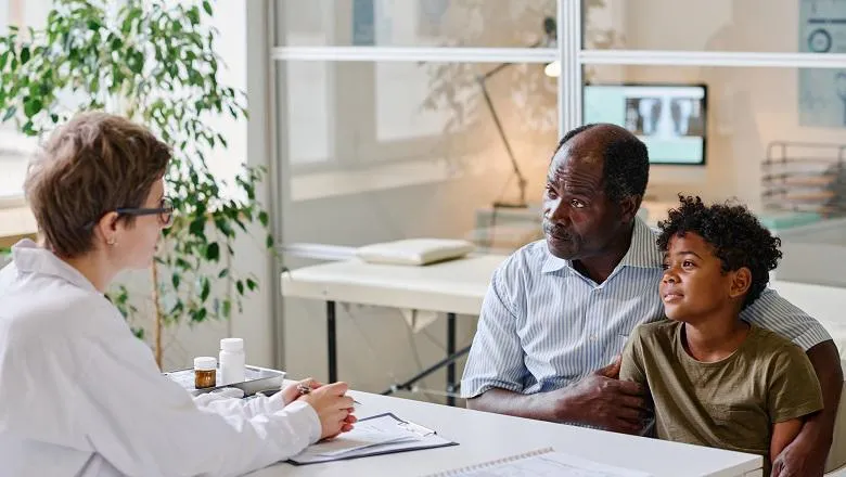 Image of child and caregiver speaking to a healthcare professional