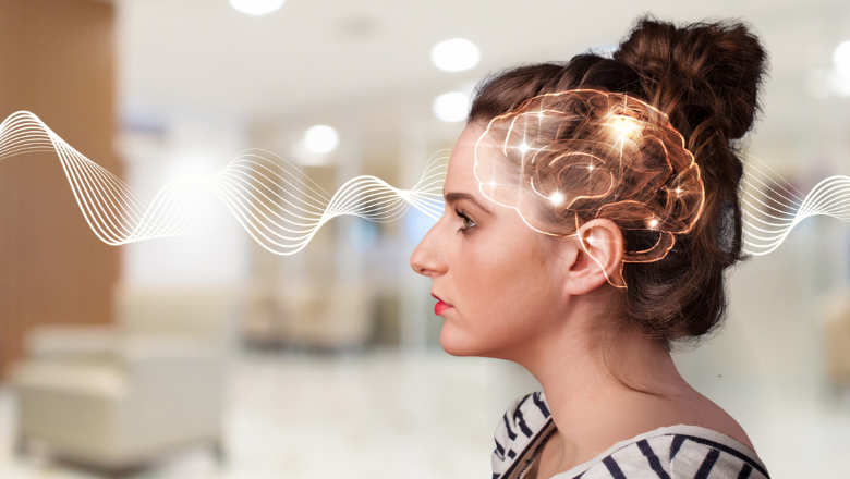 Side profile of girl looking left with glowing brain in head. Horizontal line brain waves across the image behind her head. Blurred clinic in the background
