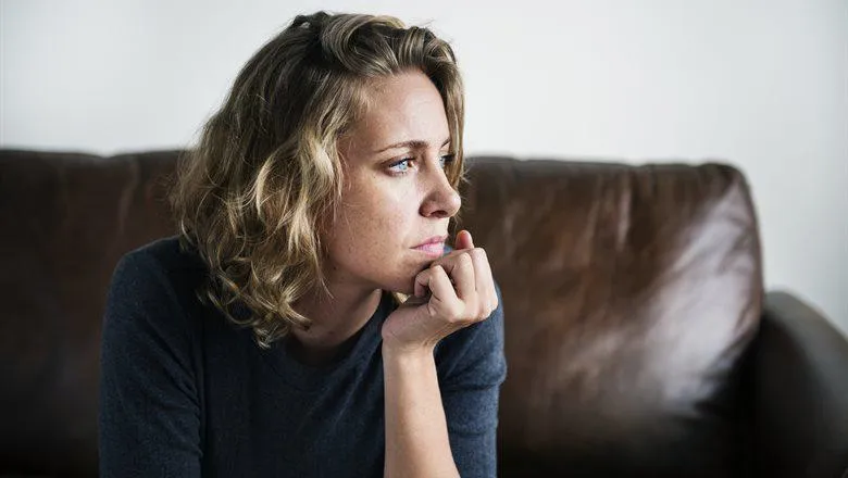 Woman resting chin on her hand looking off to the side