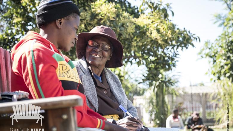 Grandmother conducting a problem solving therapy session with a young female client on the Friendship Bench  at a primary care clinic in Harare, Zimbabwe