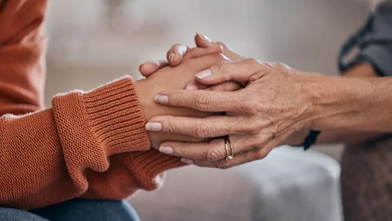 Two people comforting each other by holding hands