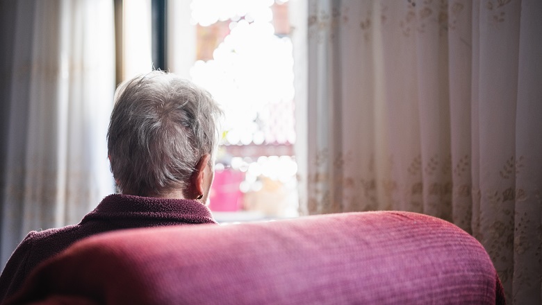 An older person sat, facing away from the camera