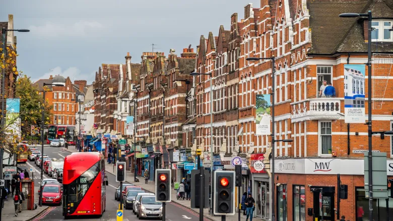 View down a London high street with shops and busy roads