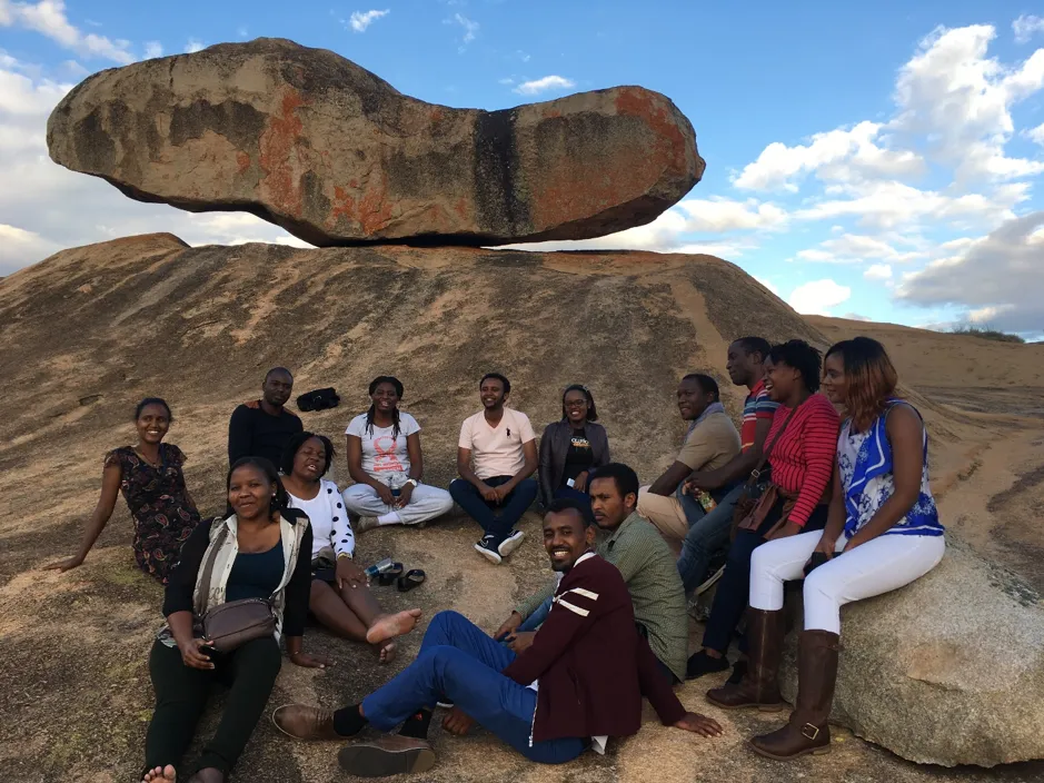 AMARI fellows sitting on a rock in Zimbabwe