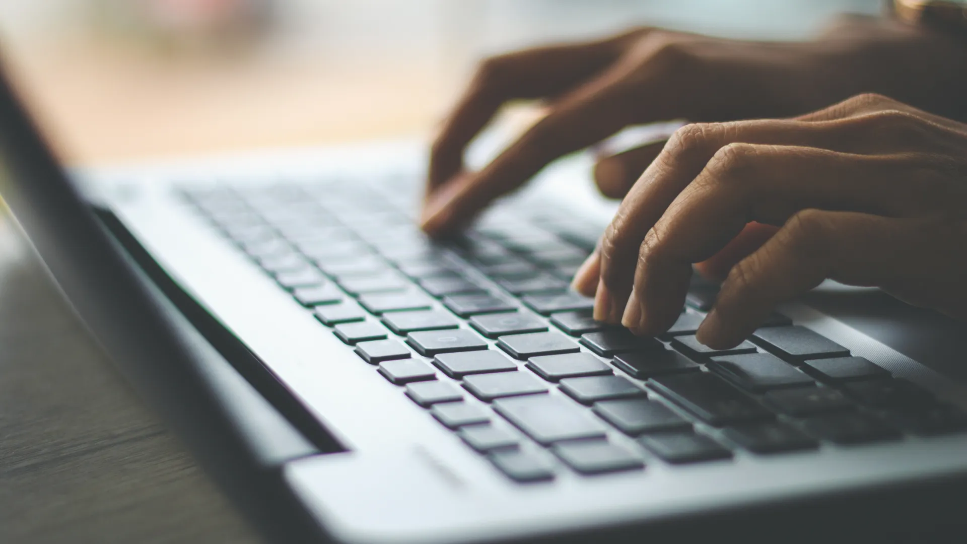 Side shot of hands on a laptop keyboard