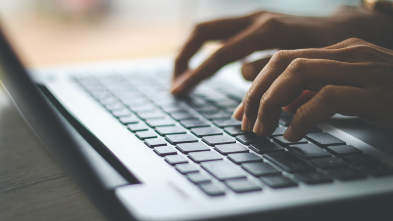 Side shot of hands on a laptop keyboard