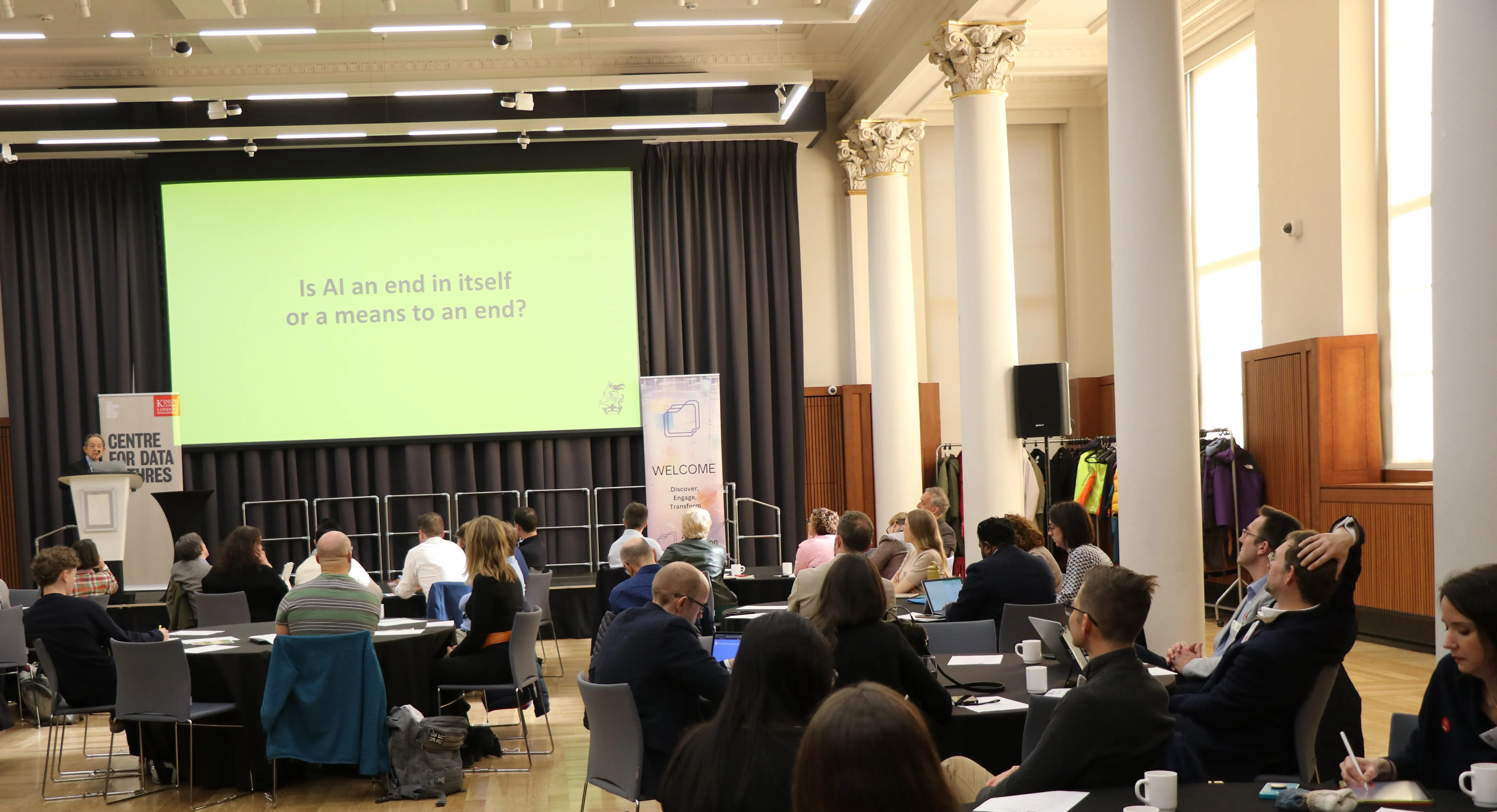 Sir Anthony Seldon speaking in front of a large group of people sitting at tables