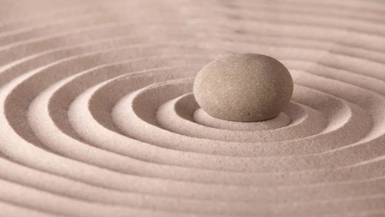 An image of spiral sand marks, with a sand stone in the centre