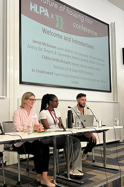people sitting on a panel in front of a presentation screen