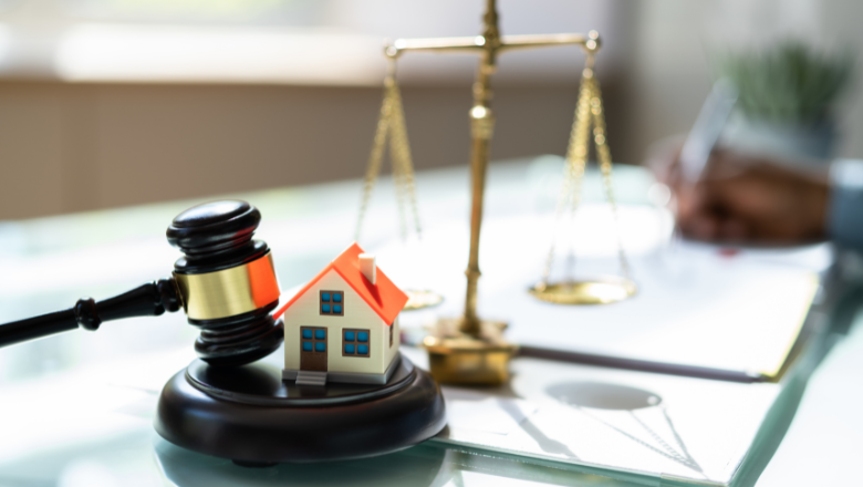 Full image of Image of a gavel and a house with weighing scales in the back
