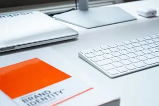 a keyboard and book on brand identity 