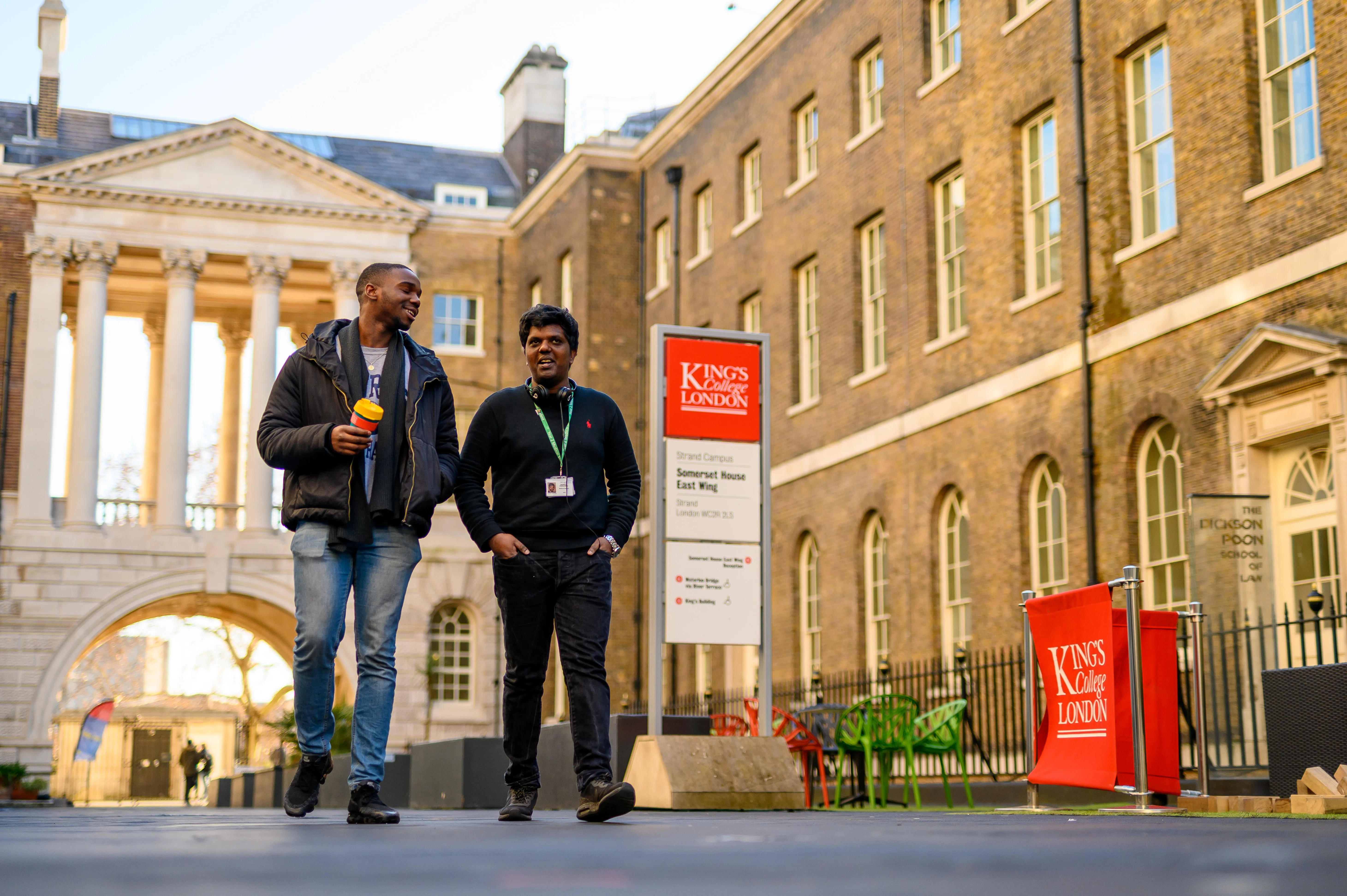 Two students are walking in the quad