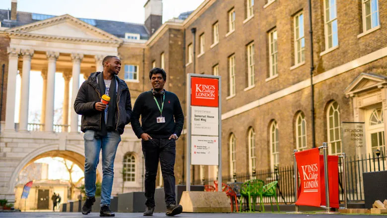 Two students are walking in the quad