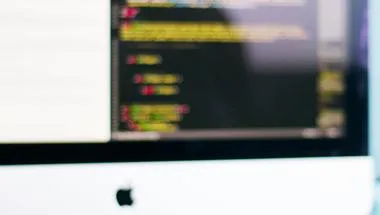 person typing at computer displaying code