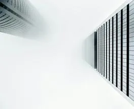 view from the bottom looking up at two buildings towering into the sky
