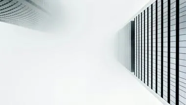 view from the bottom looking up at two buildings towering into the sky