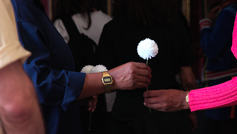 Two people passing a white flower between them