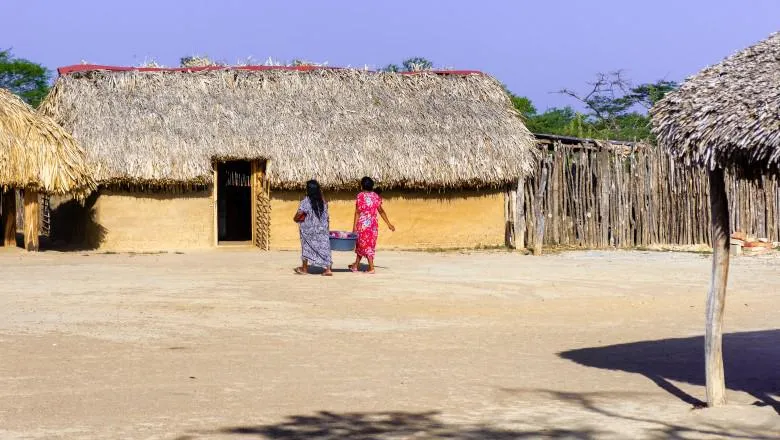 Woman walk through a traditional Wayuu settlement, La Guajira Department, Colombia.