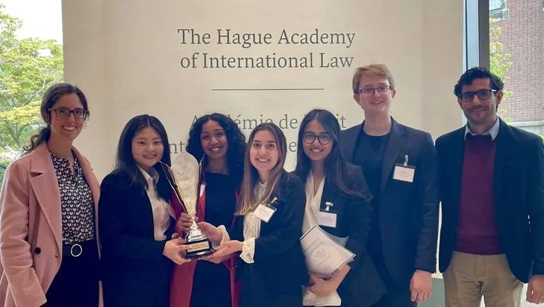 The King's Day of Crisis Moot team gathered together holding a trophy