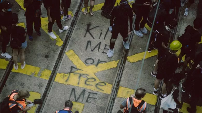 A slogan, 'Kill me or free me' has been graffitied on a road.