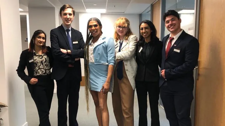 law students group- a group of people smiling in an office corridor. 