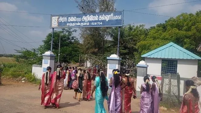Women dressed in colourful saris walking towards a building. 