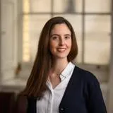 A woman with long brown hair is smiling for a head shot