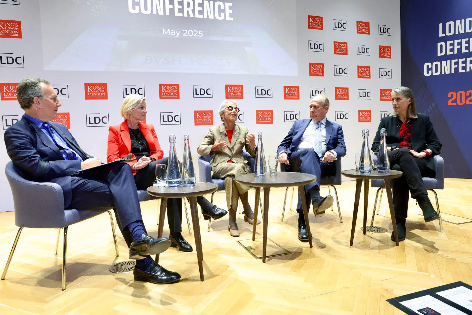 Five people speaking at an event