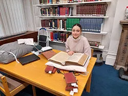 Image of an MA intern researching in a library reading room
