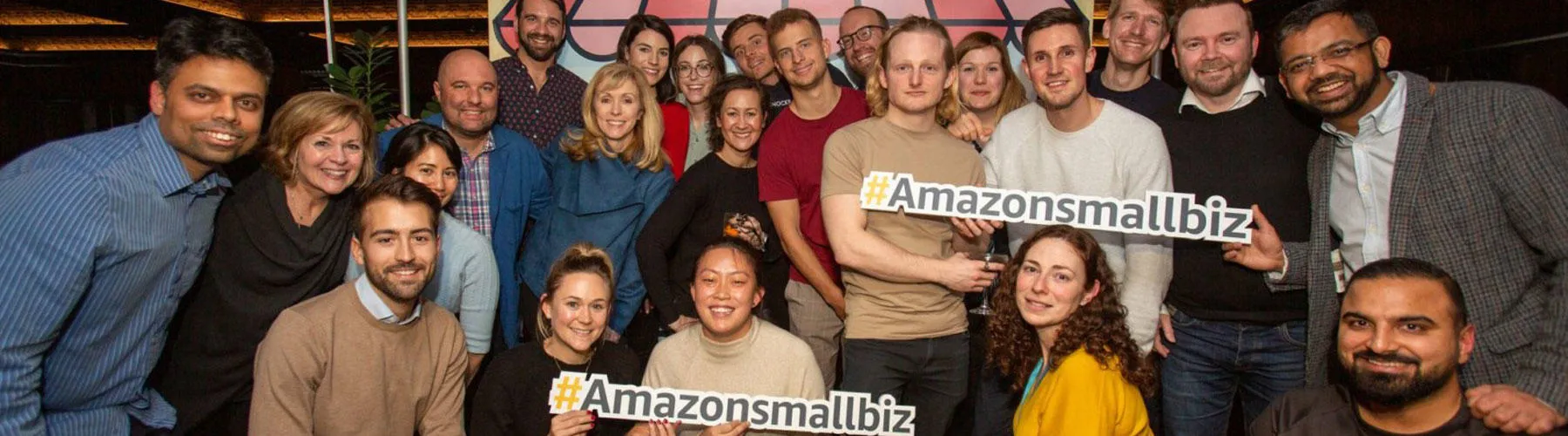 A group of people holding signs about the Amazing Small business awards