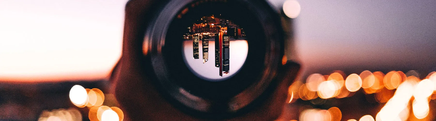 shallow focus photography of person holding camera lens