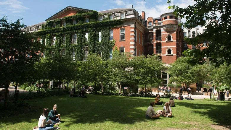 Image of Guy's campus on a sunny day, with students sitting on the grass