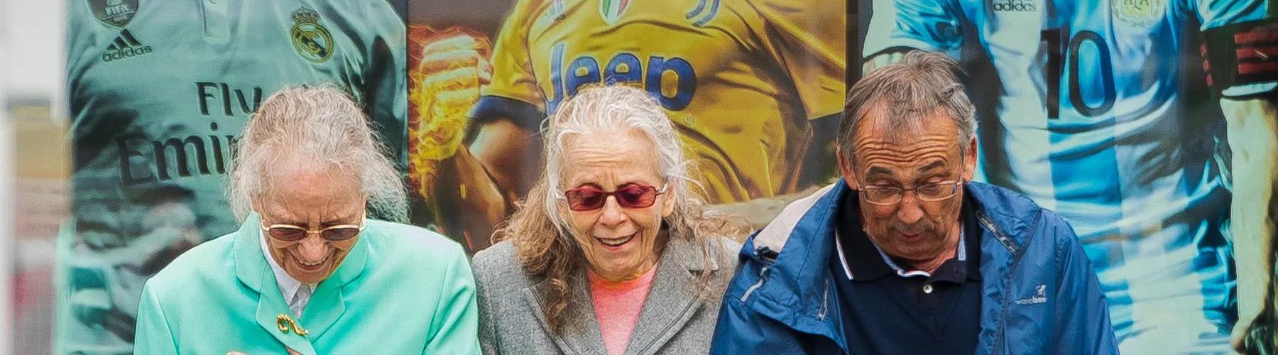 Three happy elderly people linking arms