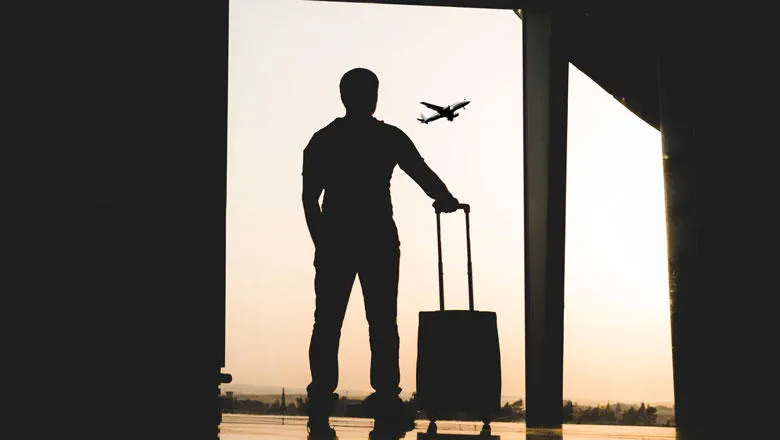 silhouette of man holding luggage inside airport