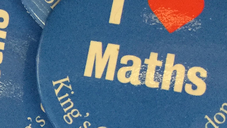 Close up of a pile of blue 'I heart maths' badges from King's