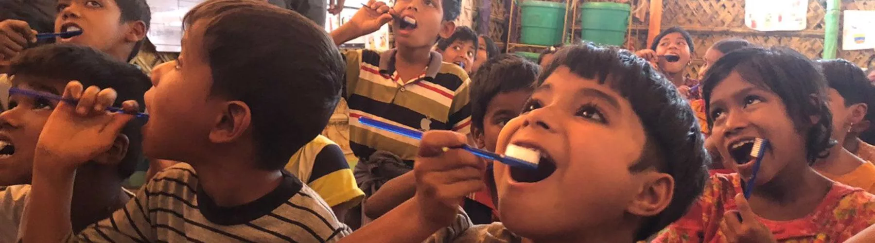 Children practice brushing their teeth