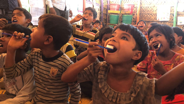 Children practice brushing their teeth
