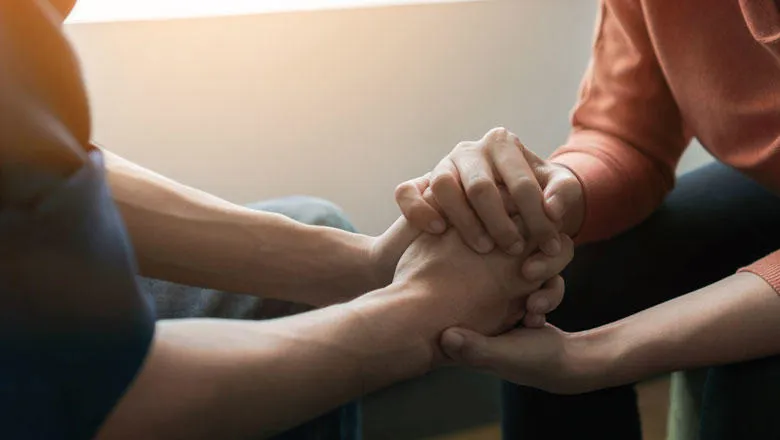 Two people clasp hands