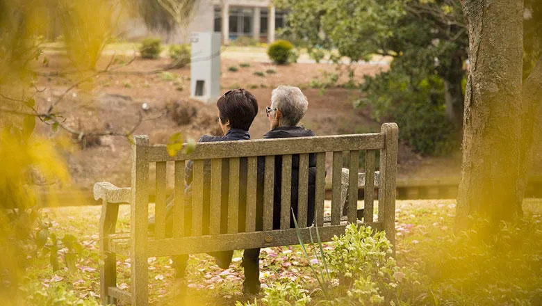 Two people sit on a bench