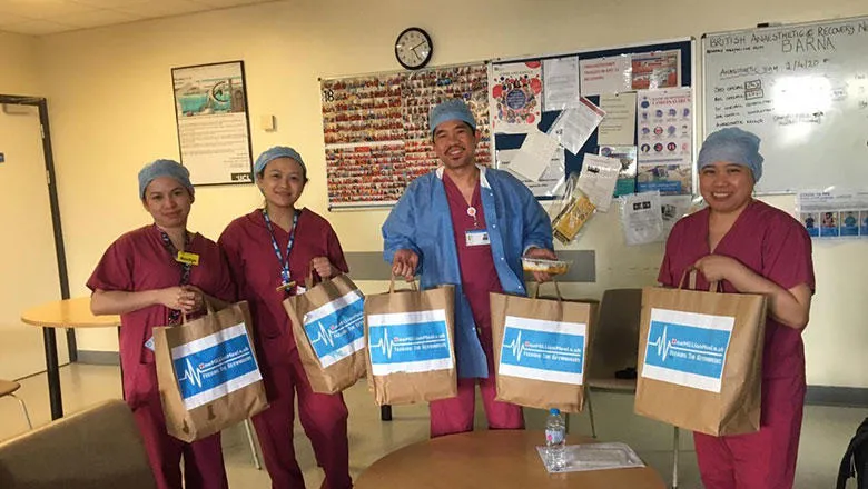 Four medics hold up bags of food