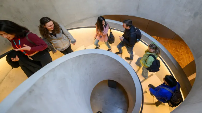 Students walking up a spiral staircase on campus