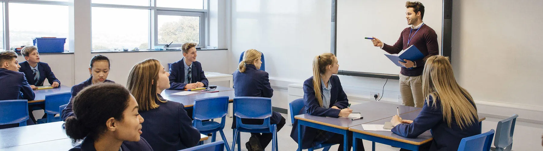 Teacher and students in uniform in a classroom