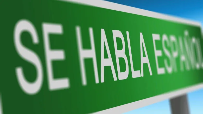 Green sign with white writing 'Se habla Espanol'