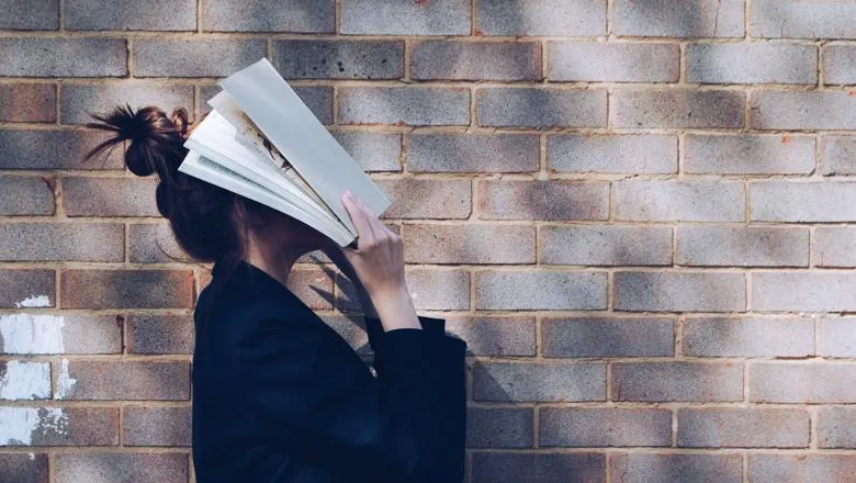 Person covering face with a book