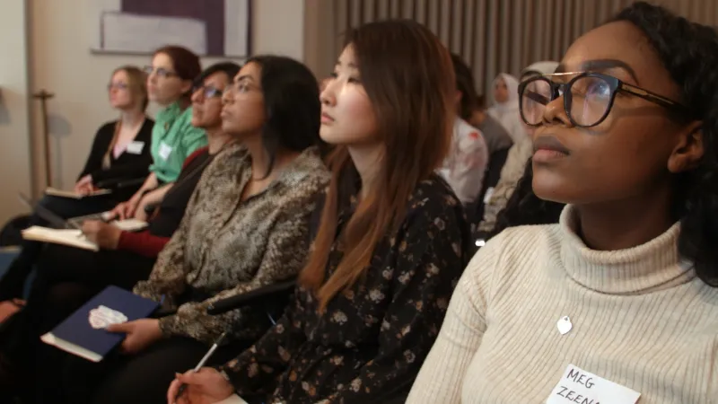 Members of the women entrepreneurs network sitting in rows listening to a speaker.