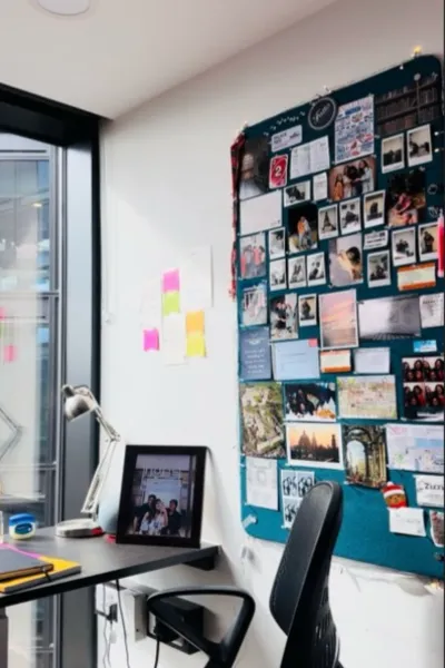 A student's desk area in their bedroom in King's Residences. There is a noticeboard with pictures attached.