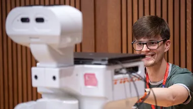 A student interacting with TIAGo robot