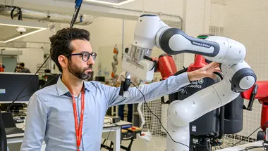 A researcher adjusting a robotic arm